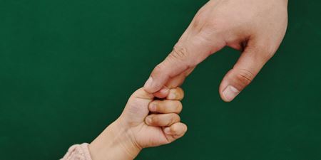 En barne- og en voksenhånd rækker ud efter hinanden. Foto: Frederikssund Kommune