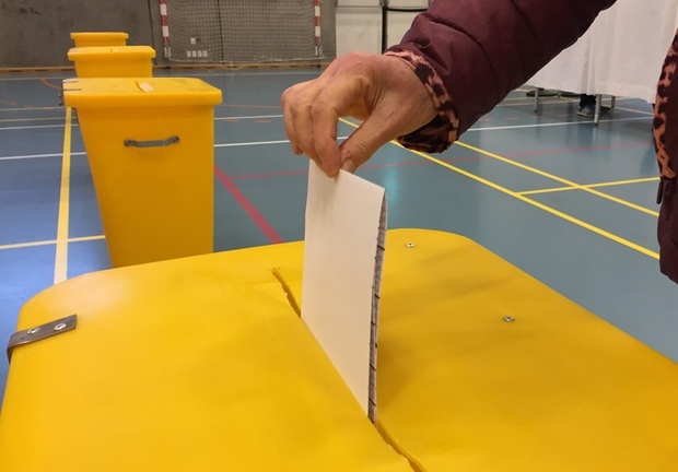 Hånd lægger stemmeseddel i valgurnen. Foto: Frederikssund Kommune.