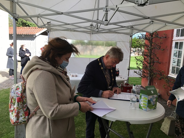 Borgmesteren og de nye statsborgere underskriver papirer. Foto: Frederikssund Kommune.