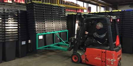 Truck sætter affaldsbeholdere i stakke på lageret i Jægerspris. Foto: Frederikssund Kommune.