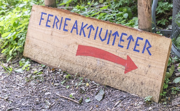 Træskilt med ordet Ferieaktiviteter skrevet på og en rød pil der peger mød højre. Foto: Frederikssund Kommune, Kenneth Jensen