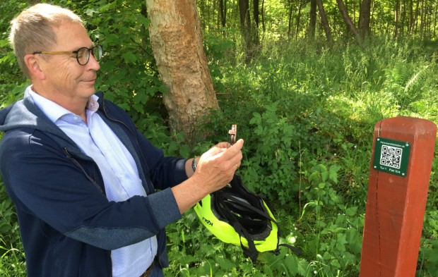 Formanden for Plan- og Miljøudvalget, Jørgen Bech, tester her en af de 121 QR-koder, der er opsat rundt omkring i Naturparken. Her kan besøgende få information om parkens natur, historie mv. Foto: Frederikssund Kommune.