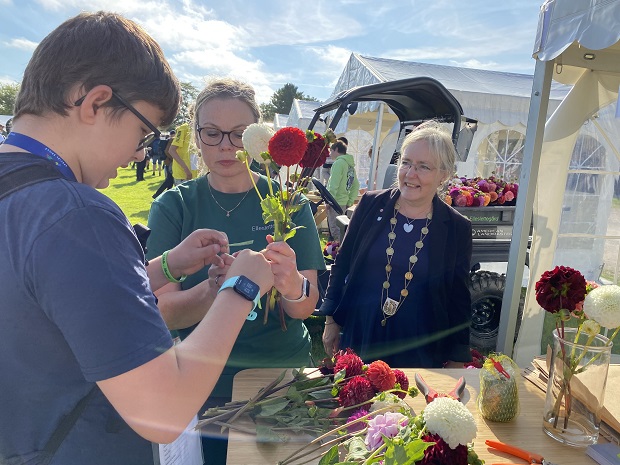 Borgmester Tina Tving Stauning kigger på en elev lave blomsterbinding. Foto: Frederikssund Kommune, Mikala Tordrup.