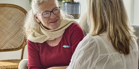 Ældre person smiler til anden person. Foto: Demensvenligt Danmark