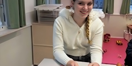 Karla sidder ved et bord. Foto: Frederikssund Kommune