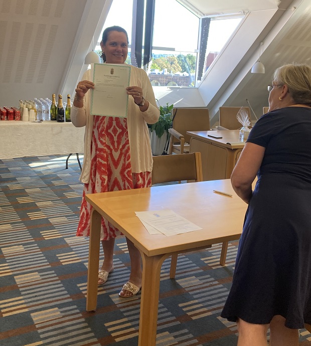 Kvinde viser papirerne på sit nye statsborgerskab frem. Foto: Frederikssund Kommune.