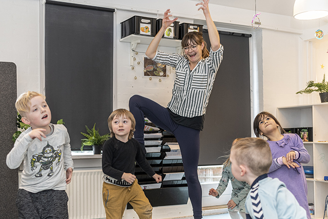 Instruktør og børn hopper højt og danser rundt. Foto: Kenneth Jensen, Frederikssund Kommune.