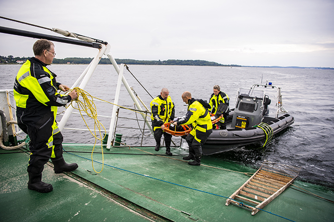 Den bjærgede passager bæres ombord på færgen. Foto: Kenneth Jensen., Frederikssund Kommune.