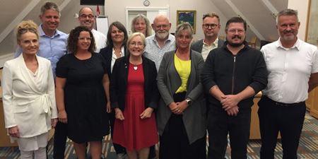 Borgmester Tina Tving Stauning (midtfor i rødt) flankeret af gruppeformændene i Byrådet. Foto: Frederikssund Kommune.