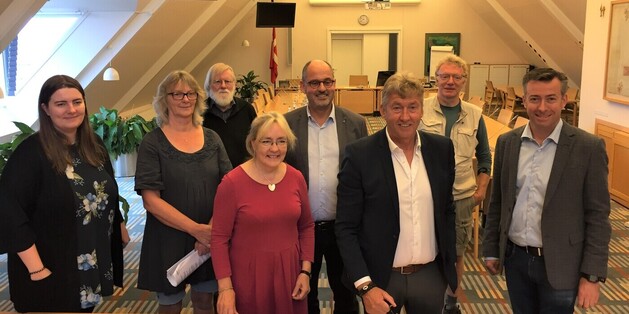 Fra venstre ses: Maria Katarina Nielsen (R), Inge Messerschmidt (O), Pelle Andersen Harild (Ø), Tina Tving Stauning (S), Niels Martin Viuff (C), borgmester John Schmidt Andersen (V), Ole Frimann Hansen (SF), Hans Andersen (V). Foto: Frederikssund Kommune.