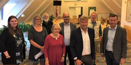 Fra venstre ses: Maria Katarina Nielsen (R), Inge Messerschmidt (O), Pelle Andersen Harild (Ø), Tina Tving Stauning (S), Niels Martin Viuff (C), borgmester John Schmidt Andersen (V), Ole Frimann Hansen (SF), Hans Andersen (V). Foto: Frederikssund Kommune.