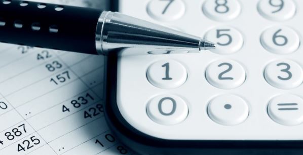 Lommeregner, kuglepen og papirer med tal. Foto: Colourbox.