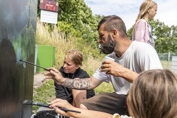 Kristian Vodder Svensson viser børn, hvordan de skal male. Foto: Frederikssund Kommune, Kenneth Jensen.