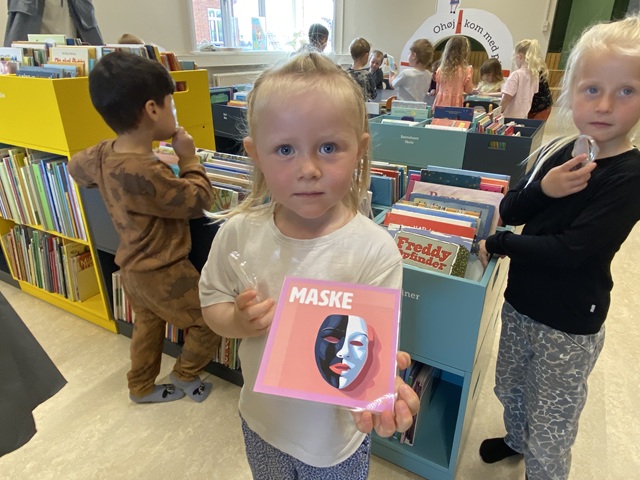 En pige har fundet et ord på biblioteket. Foto: Frederikssund Kommune.