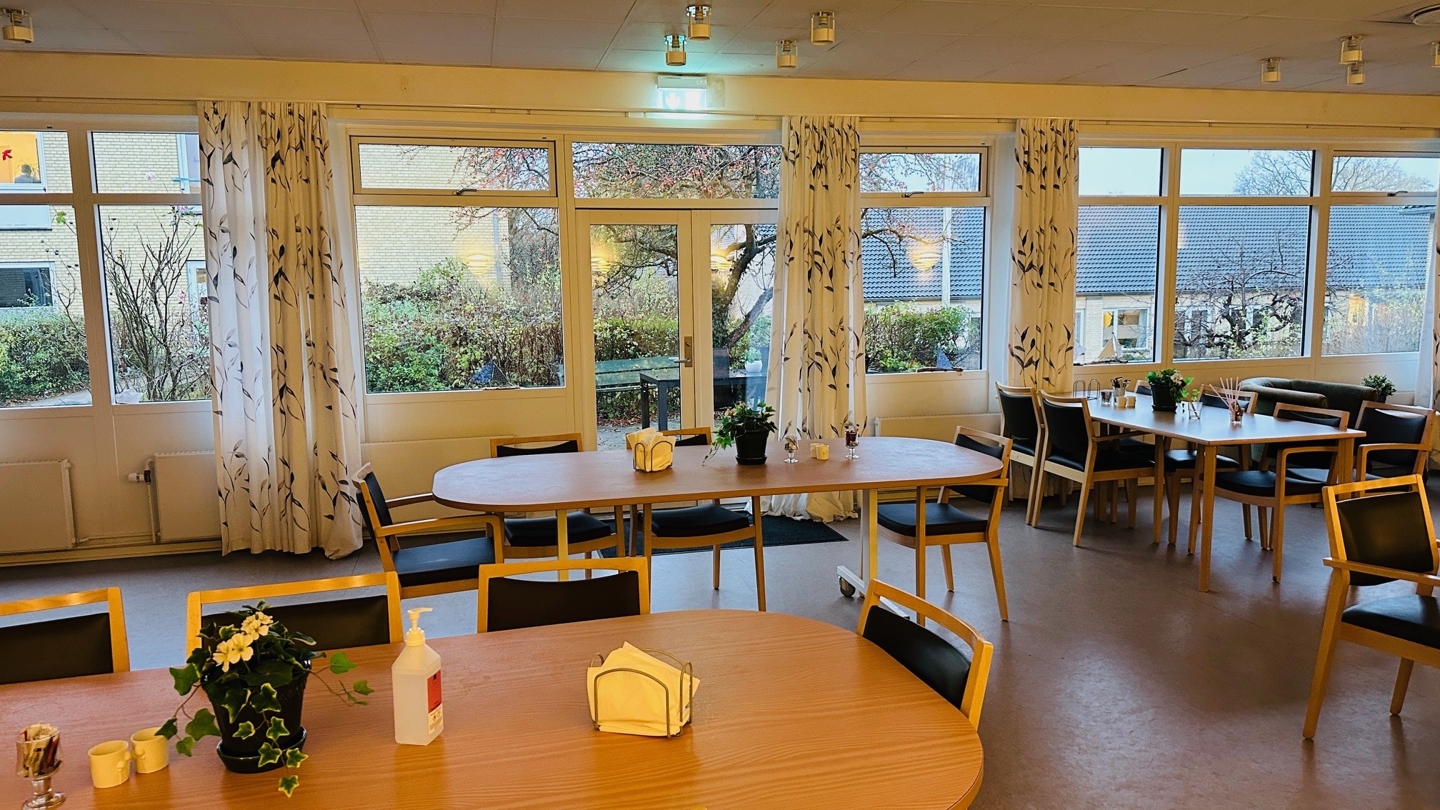 Tre borde med siddepladser og udsigt til haven