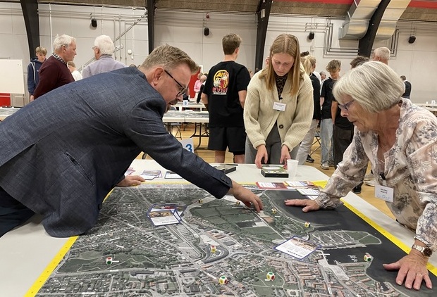 Personer står om et bord og peger og taler om kystbeskyttelse. Tv. ses formand for Klima, natur og energi, Søren Weimann (B). Foto: Frederikssund Kommune.