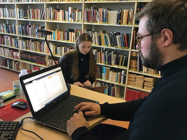 Mikkel Kræmer Storm hjælper Anna Hasfeldt Sørensen på skolebiblioteket på Frederikssund Gymnasium. Foto: Frederikssund Kommune.