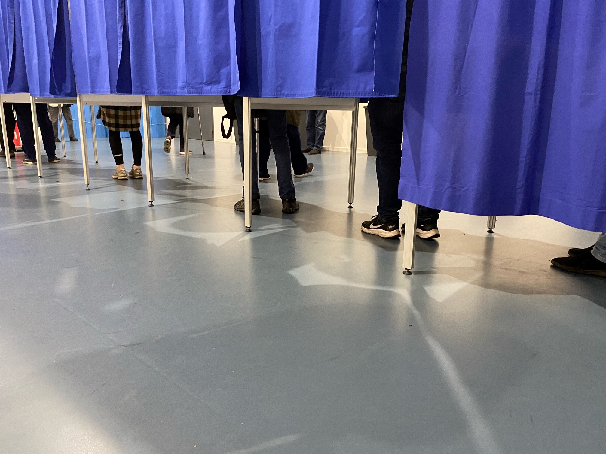 Række af fødder i stemmebokse. Foto: Frederikssund Kommune